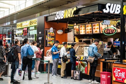 Ciudadanos chinos hacen cola en un restaurante de comida rápida en una estación de tren de Sanghái.