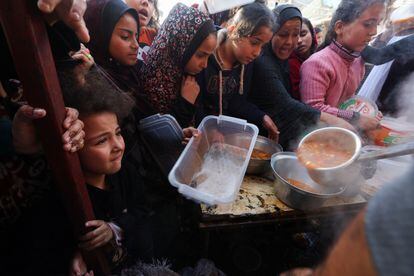 Palestinos esperan recibir alimentos repartidos por voluntarios en Rafah, al sur de la Franja. 