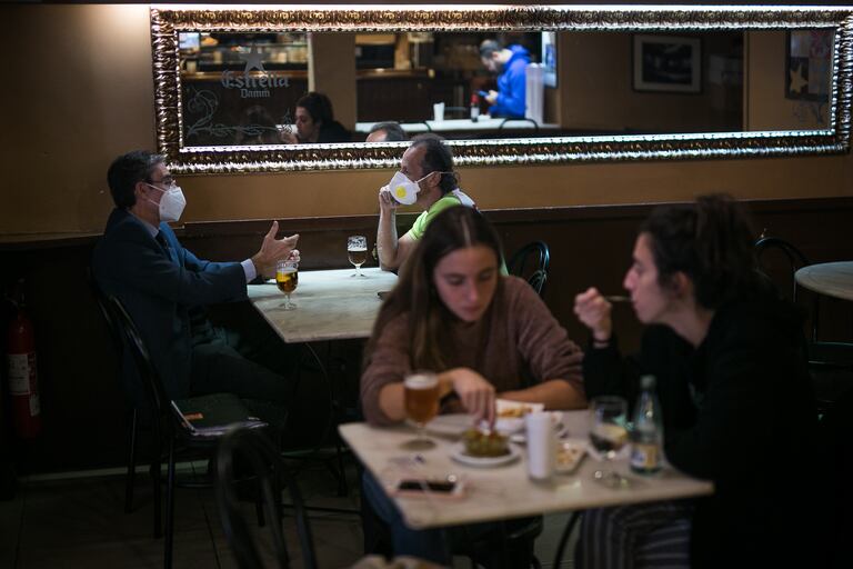 Varios clientes con y sin mascarillas en un bar de Barcelona, este jueves.