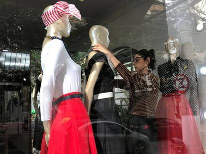 Una mujer cambia el vestuario de maniquíes en una tienda de Sao Paulo.