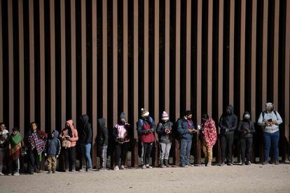Migrantes en búsqueda de asilo hacen fila para ser procesados por agentes de la Patrulla Fronteriza estadounidense