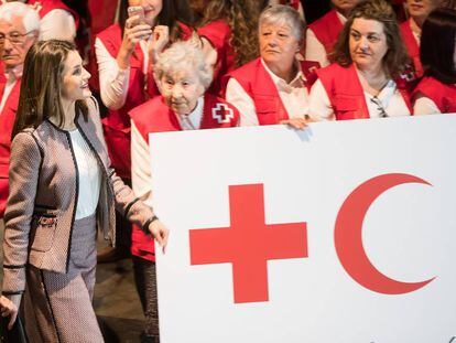 La reina Letizia saluda a su llegada a los voluntarios de la Cruz Roja presentes en el acto del Palacio de Congresos de Santiago.