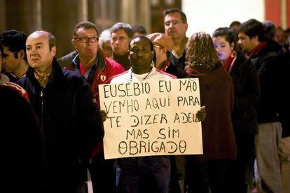Un hombre espera en la cola para presentar sus respetos a Eusebio con un cartel que dice "Eusebio no he venido aquí para decir adiós. He venido aquí para decir gracias".