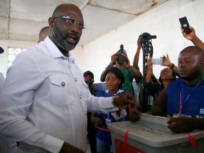 El exfutbolista George Weah (c), ejerce su derecho al voto en la segunda vuelta de las elecciones presidenciales en Monrovia este martes.