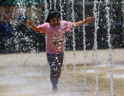 Una niña se baña en una fuente en la Ciudad de México.