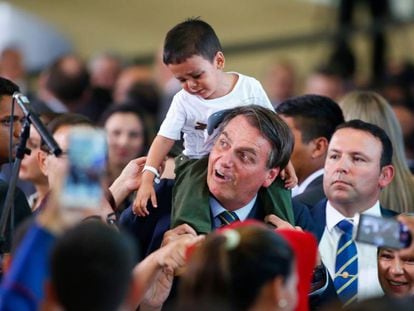 El presidente Bolsonaro carga a un niño venezolano. 