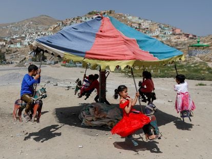 Niños afganos juegan en un carrusel durante el festival musulmán de Eid al-Adha,  en Kabul, Afganistán, el 31 de julio de 2020.