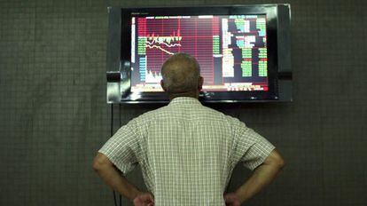 Un inversor sigue la evolución de la Bolsa en Pekín (China)