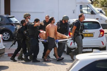 Personal de seguridad trasladaba este sábado a una persona herida tras el ataque de las milicias palestinas en la ciudad israelí de Ashkelón. 