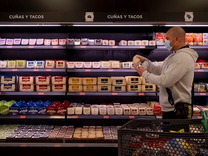 Un vecino de Sevilla hace la compra en una de las tiendas de Mercadona donde está implantado ya el laboratorio de quesos nacionales.