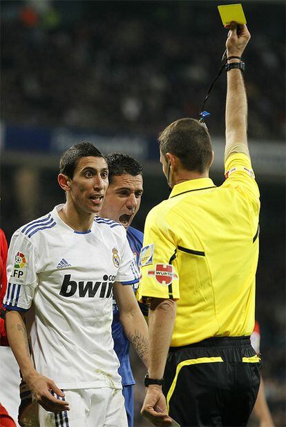 Clos Gómez muestra una tarjeta amarilla a Di María durante el encuentro entre el Real Madrid y el Sevilla.