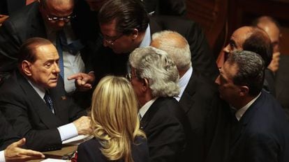 Berlusconi habla con otros senadores en el voto de confianza a Letta.