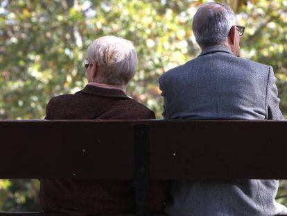 Dos ancianos sentados en el banco de un parque público de Madrid.
