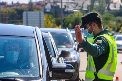 Un agente de la Guardia Civil da el alto a un vehículo durante un control a la salida de Madrid, el pasado día 10.