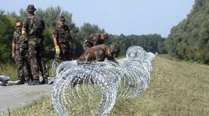 Soldados del ej&eacute;rcito h&uacute;ngaro contin&uacute;an construyendo la valla en la frontera con Croacia, el 18 de septiembre de 2015. 