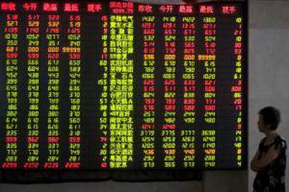 Un inversor observa los precios de la bolsa mostrados por un panel electrónico en un casa de intercambio de valores en el centro de la ciudad de Qindao, al este de la provincia de Shandong, China. EFE/Archivo