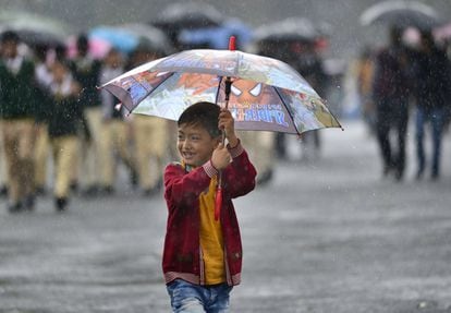 Un niño sujeta un paraguas mientras camina bajo la lluvia en Shillong, capital del estado de Meghalaya, India.