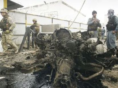 Soldados afganos y de la OTAN inspeccionan los restos de un coche bomba, ayer en Herat (oeste de Afganist&aacute;n).