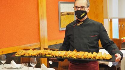 Tito Gómez, dueño del restaurante Urumea, posa con un cachopo de un metro de largo.