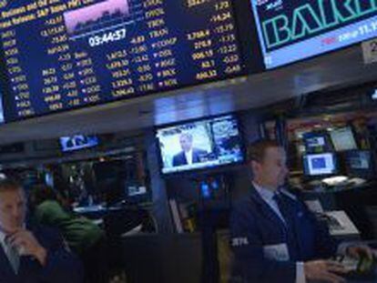 El presidente de la C&aacute;mara de Representates estadounidense, John Boehner (en pantalla), habla mientras comerciantes trabajan en la sede de la Bolsa de Nueva York.