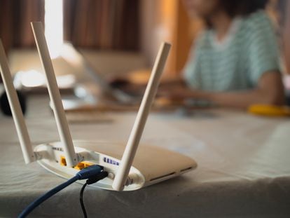 Una mujer trabaja desde casa con sus dispositivos conectados a una red wifi.