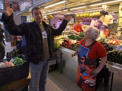 Francesc Anyó parla amb Amparo Alcolea, davant la seua parada de fruites i verdures al Mercat Central de València.