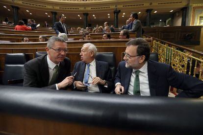 El ministro de Justicia, Alberto Ruiz-Gallardón, el de Exteriores, José Manuel García Margallo, y el presidente del Gobierno, Mariano Rajoy, en su escaño.