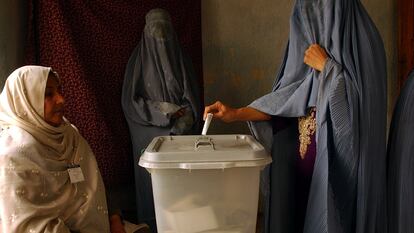 Una mujer afgana con burka mete su papeleta en una urna en Kabul en 2004, en las primeras elecciones presidenciales del país.