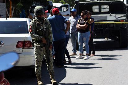 Un soldado del ejército mexicano vigila en la zona donde un chófer fue asesinado y su vehículo incendiado en Chilpancingo.