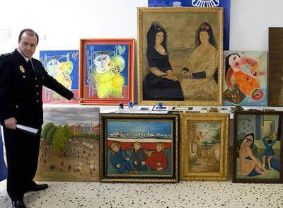 Un policía nacional muestra las trece pinturas de autores como Goya y Pinazo, algunas de ellas falsas
