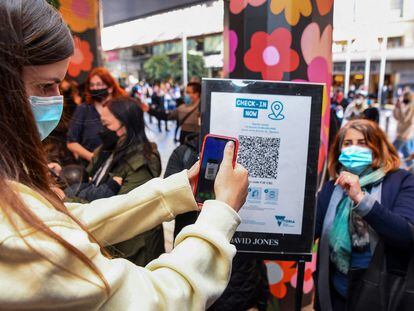 Un cliente escaneando un código QR para ingresar a una tienda en Melbourne, Australia