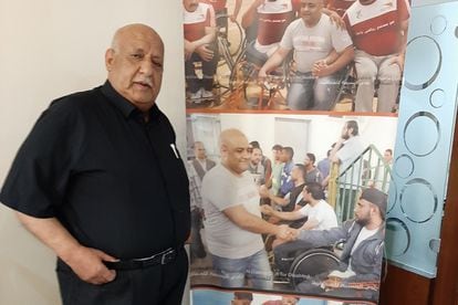 Jalil el Halabi, father of the aid worker sentenced in Israel, in May in front of a poster with photos of his son in his house in Gaza.
