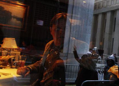 Un comensal observa desde un restaurante la protesta de 'Ocupa Wall Street'.