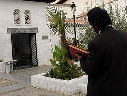 Un musulman en el jardín de la mezquita Mayor de Granada con un Corán en las manos.