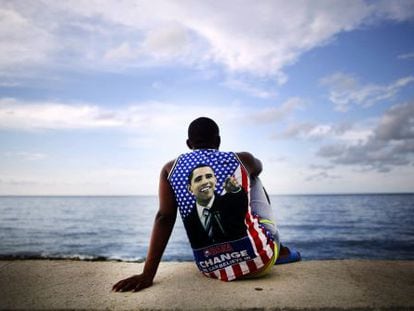 Un joven cubano sentado en el malec&oacute; de La Habana con una camiseta de Obama.  