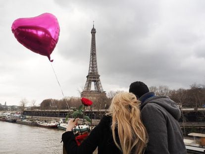 Una pareja celebra el día de San Valentín en frente de la Torre Eiffel.