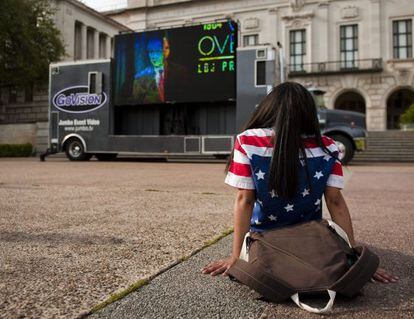 Una joven estudiante observa una transmisión del expresidente George W. Bush en el marco de la Cumbre de Derechos Civiles
