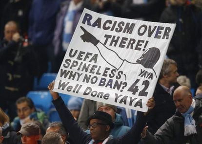 Un aficionado sostiene una pancarta contra el racismo denunciando los cánticos sufridos por el jugador del Manchester City Touré yayá en Moscú.