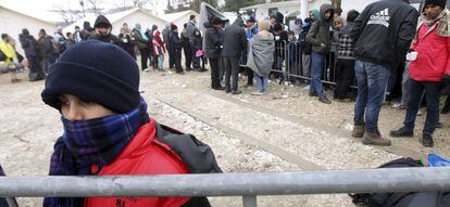 Refugiados sirios, iraqu&iacute;es y afganos caminan por un camino nevado en Miratovac, en la frontera entre Serbia y Macedonia.