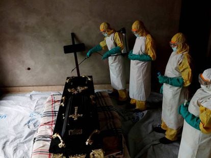 Varios sanitarios desinfectan el ataúd de una posible víctima de ébola en República Democrática del Congo, el pasado diciembre.