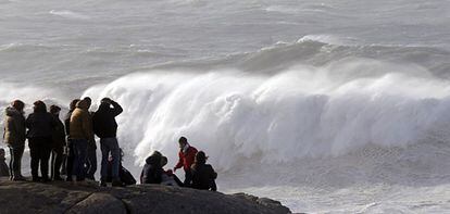 Un grupo de personas observa el fuerte oleaje en la costa de Muxía.