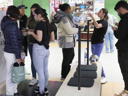 Colas para fotografiarse el iris para registrarse en Worldcoin en el pequeño puesto del Intercambiador de Avenida de América (Madrid)..