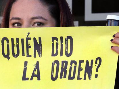 Una mujer sostiene un cartel de protesta frente a la JEP, en Bogotá.