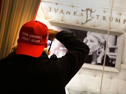 Un hombre con una gorra con el eslogan de campaña de Trump, "Make America Great Again" (Haz que América vuelva a ser grande), saca una foto de la marca de joyas de Ivanka Trump en el edificio Trump en Nueva York.
