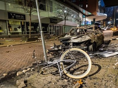 Un coche y una bicicleta calcinados tras los disturbios en Róterdam del 20 de noviembre.
