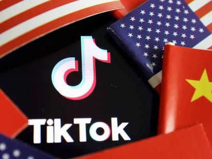Logotipo de TikTok entre banderas de China y EE UU.