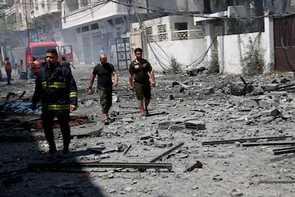 Unos bomberos inspeccionan una zona derruida por un bombardeo, este domingo en ciudad de Gaza.