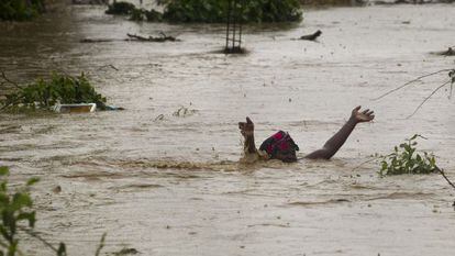 Una mujer avanza por una calle inundada en Puerto Príncipe.