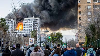 Un grupo de ciudadanos observa el incendio en el edificio del barrio de Campanar, en Valencia, el jueves.