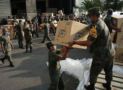 Soldados mexicanos descargan un avión de Corea del Sur con productos sanitarios.